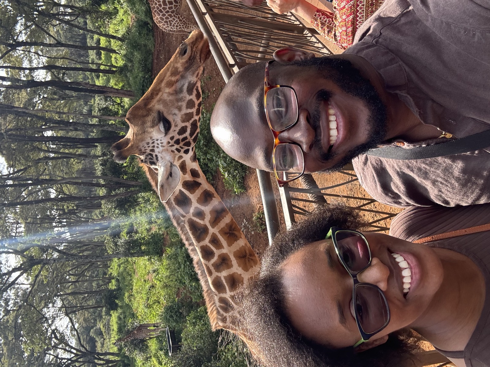 Sally and Adetunji with a giraffe at the Giraffe Centre in Nairobi, December 2024